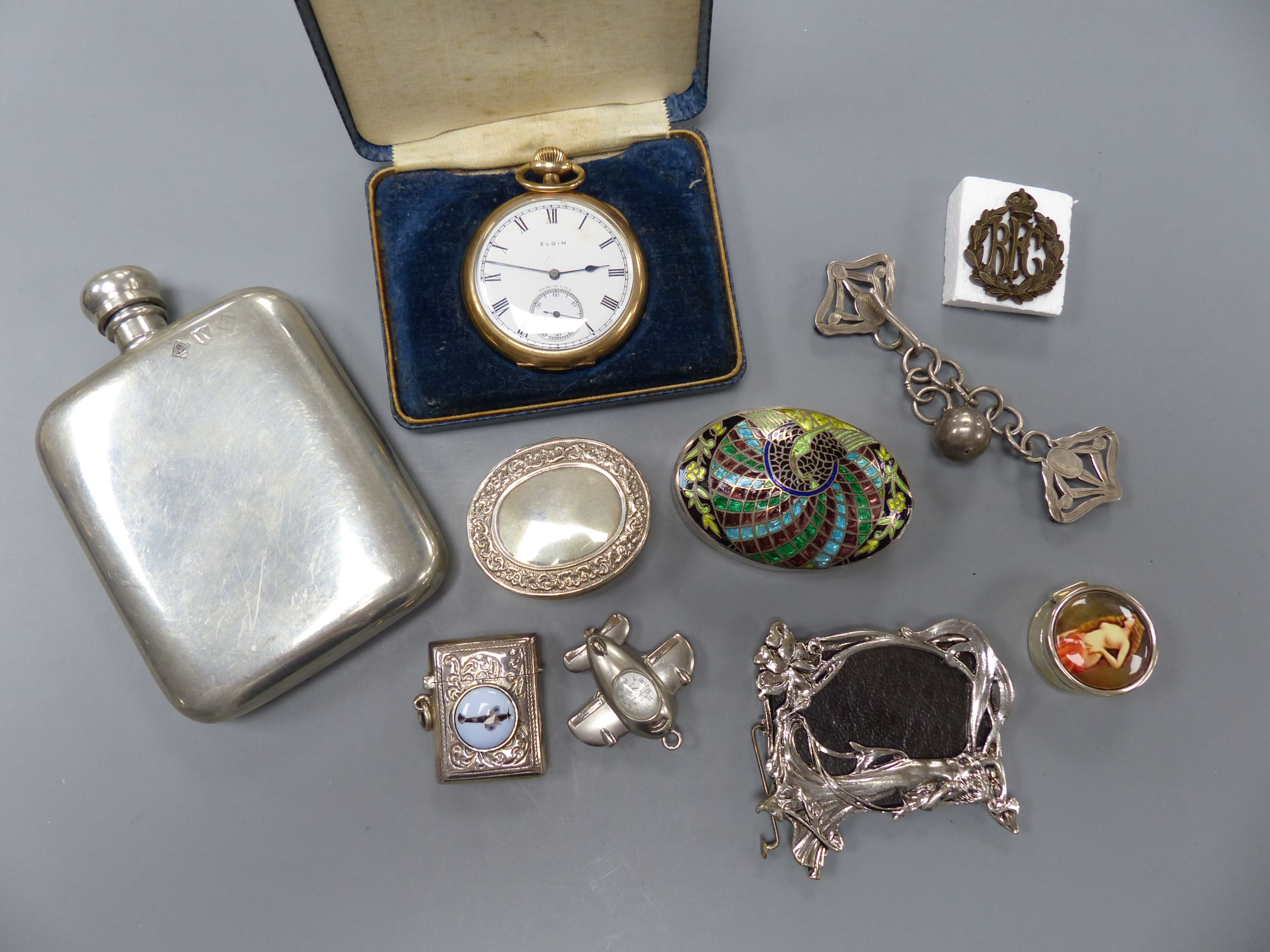 A small group of collectables including gold plated Elgin pocket watch, a 925 and enamel vesta case, three enamelled pill boxes, 'aeroplane' watch pendant, pewter hip flask, photo frame, pair of silver clips and a milita